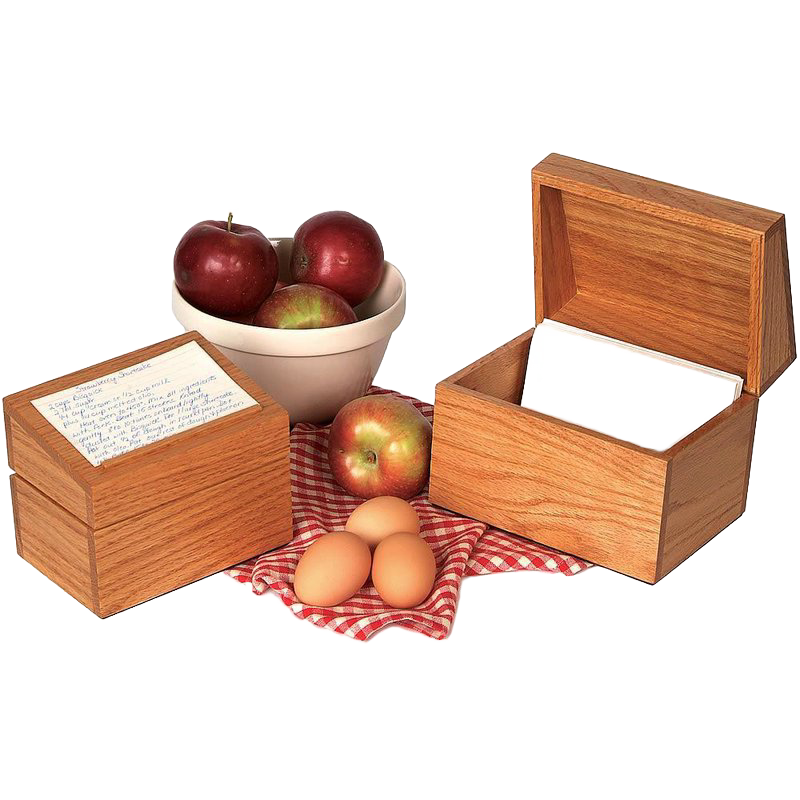 Handcrafted solid oak recipe box with smooth protective finish and recessed hinges, shown with handwritten recipe cards, fresh apples in a ceramic bowl, and eggs on a red checkered cloth, ideal for Kitchen & Food, Cookware, Baking Supplies, Holiday Hosting, Kitchen Gadgets, Kitchen Accessories, Storage and Serving, USA Made, Best Sellers, and Promo Eligible collections.