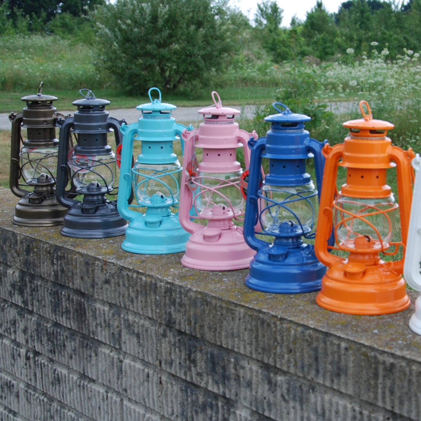 Handcrafted colorful galvanized oil lanterns with durable design arranged outdoors on a stone wall, ideal for Camping, Lamps & Lighting, Emergency Supplies, and Outdoors collections.