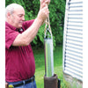 Man lifting a handcrafted galvanized steel well bucket by rope from a metal well casing outdoors, suitable for farm, garden, emergency, and best sellers collections.