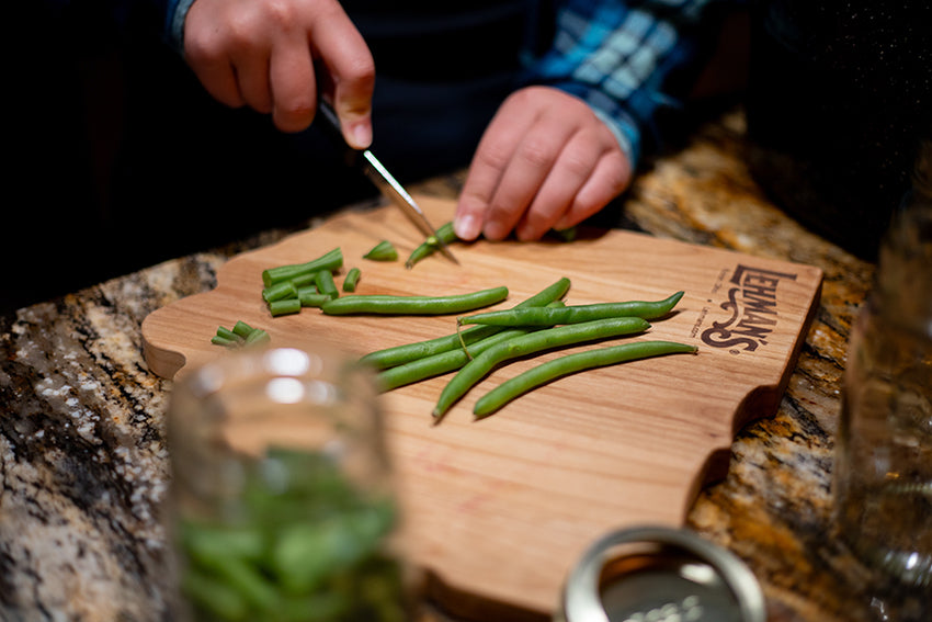 Chopping green beans on wooden cutting board