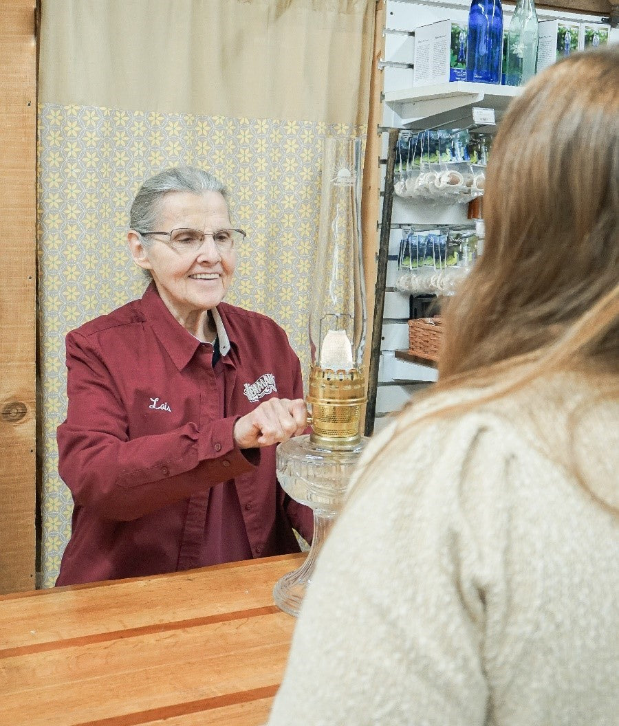 Lehman's employee helping customer with Aladdin oil lamp