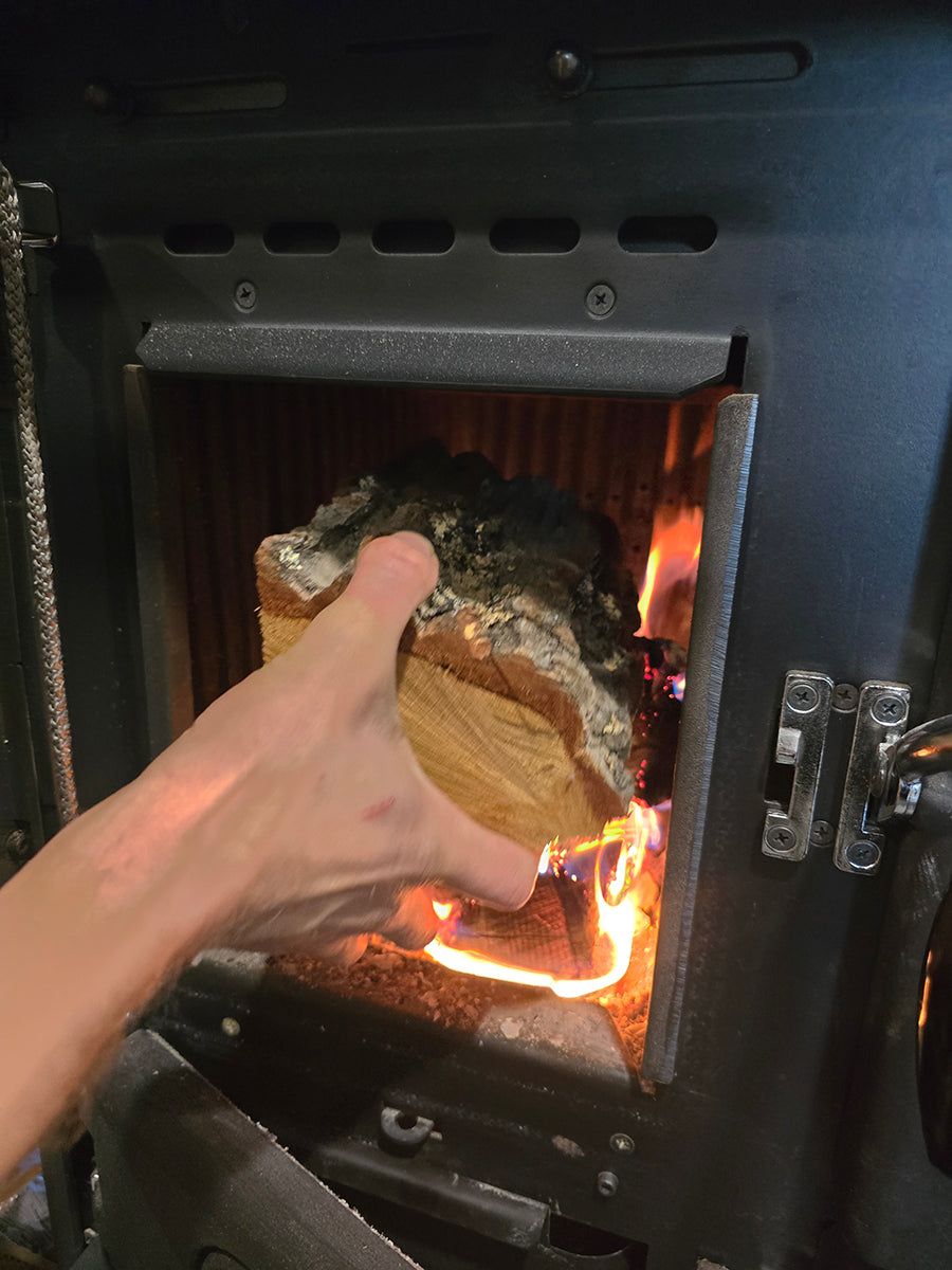 Adding wood to La Nordica cookstove