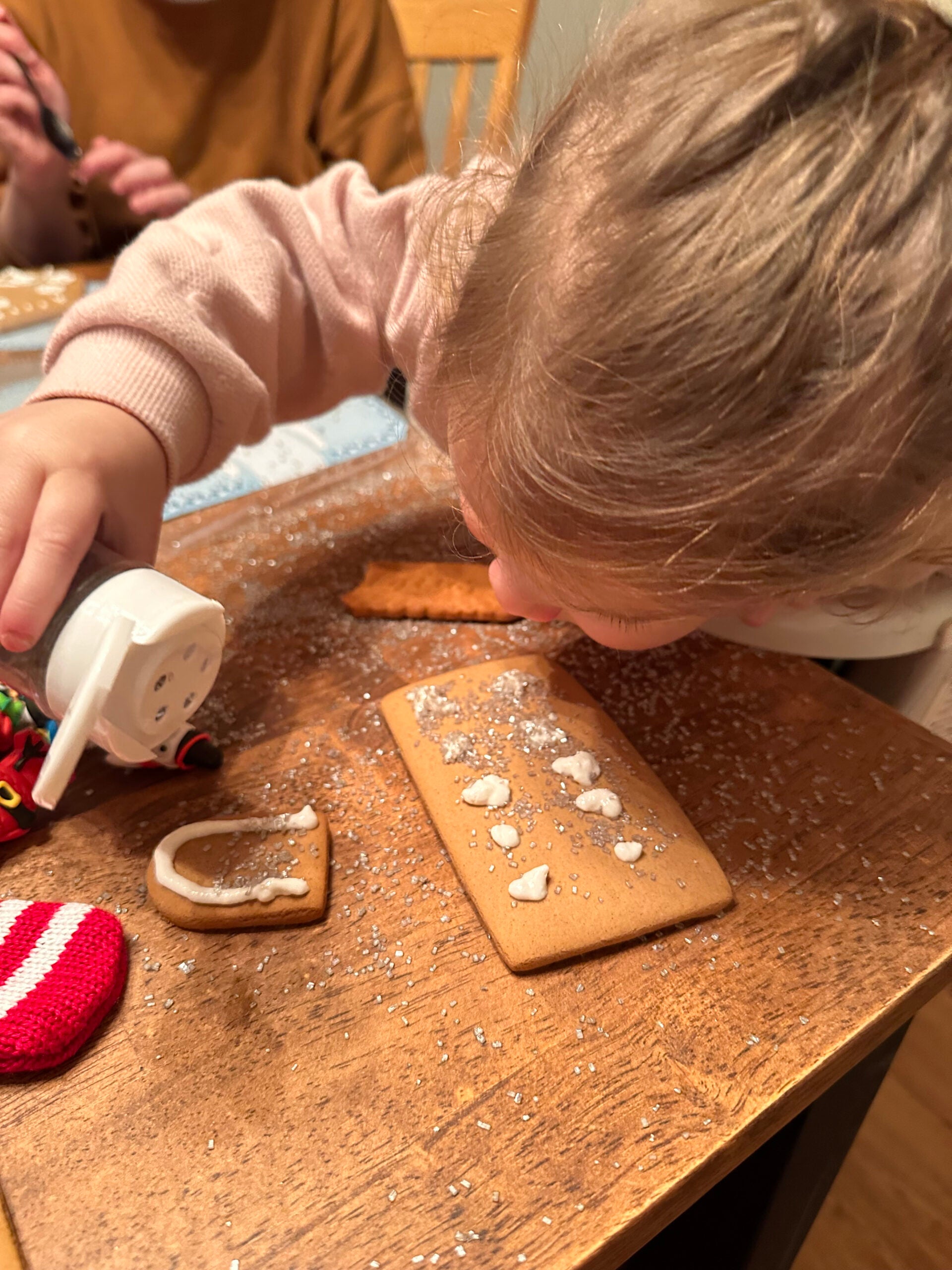 Adding more glitter to gingerbread house