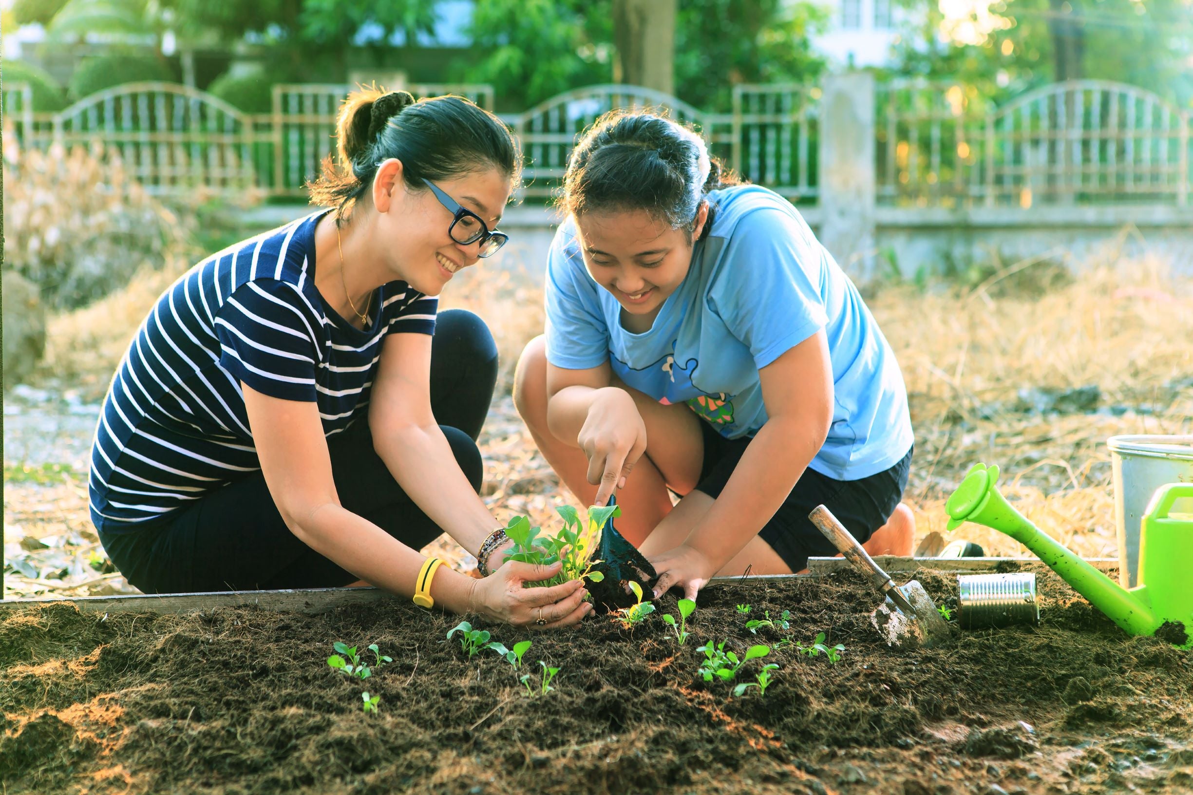 daughter and mom planting garden