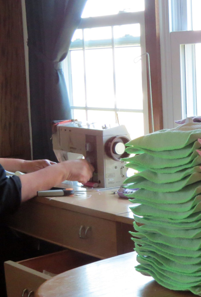 Mary works busily on a stack of microfiber mop heads for our Amish Wall Mop.